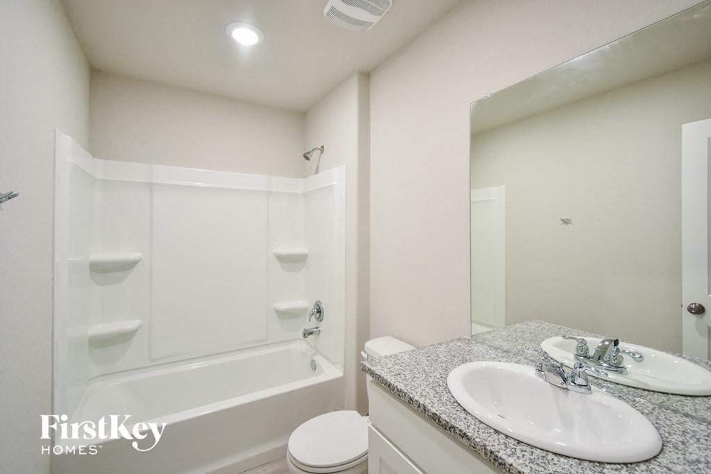 a bathroom with a sink and a bath tub and a mirror