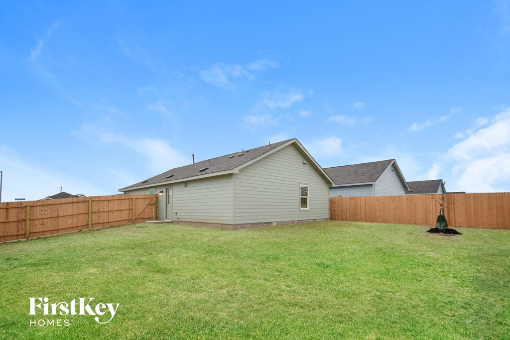 the backyard of a house with a yard and a wooden fence