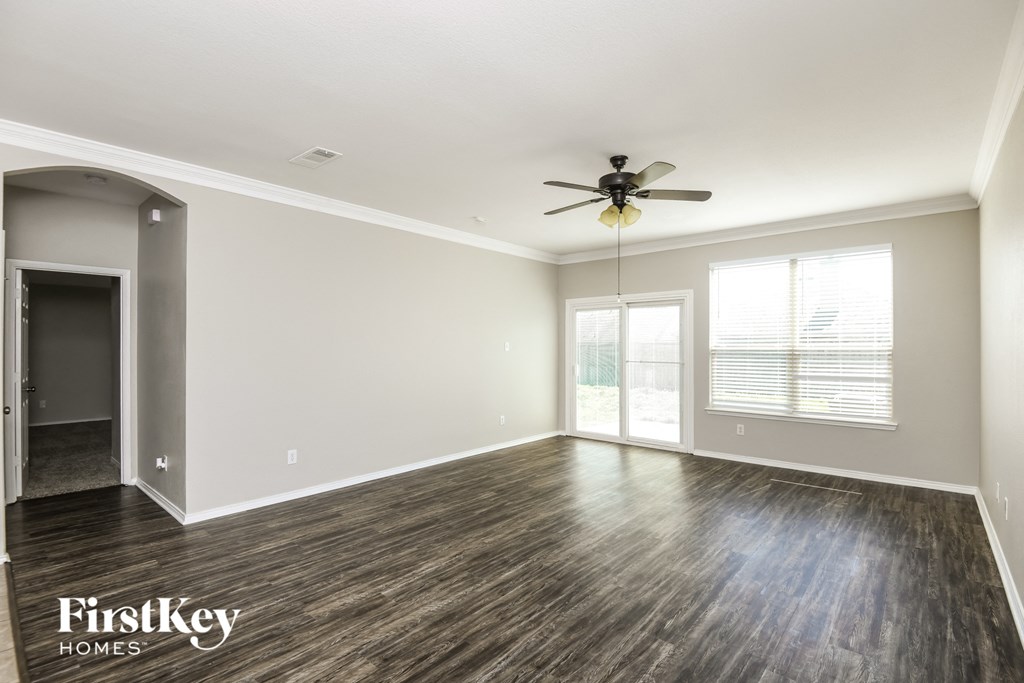 the living room of an empty house with a ceiling fan