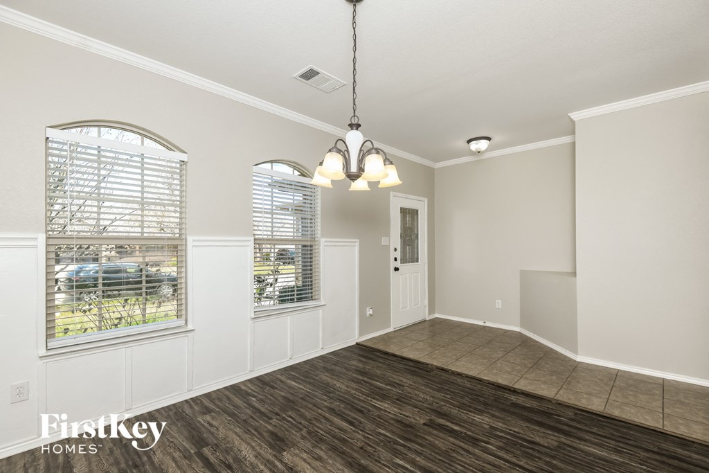 an empty living room with wood flooring and white walls