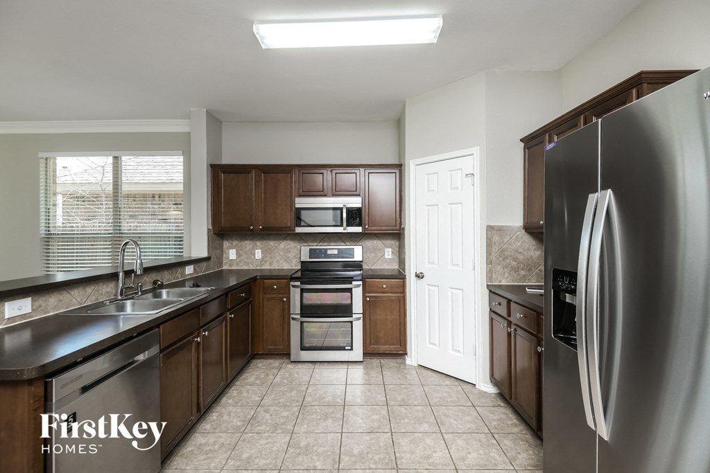 a kitchen with stainless steel appliances and wooden cabinets