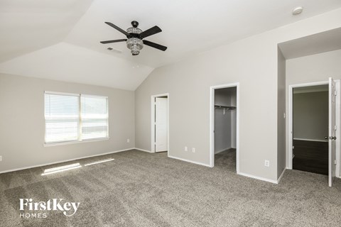 a living room with carpet and a ceiling fan