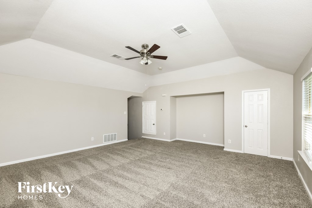 the living room with carpet and a ceiling fan