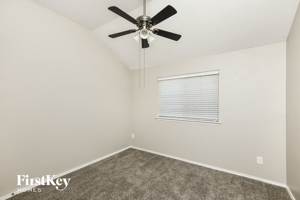 a bedroom with a ceiling fan and a window