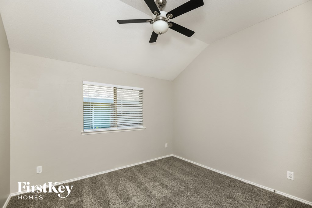a bedroom with a ceiling fan and a window