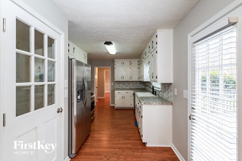 a kitchen with white cabinets and a stainless steel refrigerator
