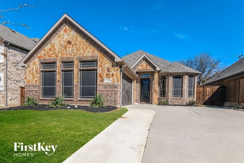 a large brick house with a driveway and a garage door