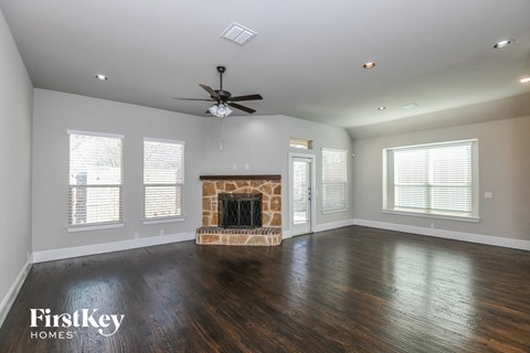 a living room with a fireplace and a ceiling fan