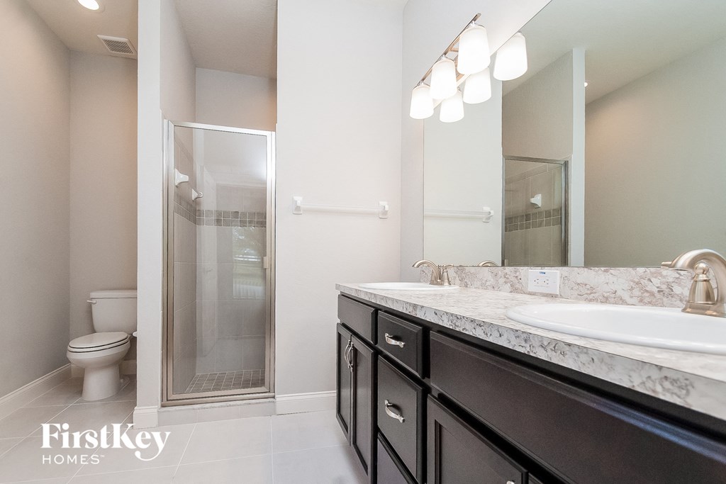 a bathroom with a sink and a shower and a toilet