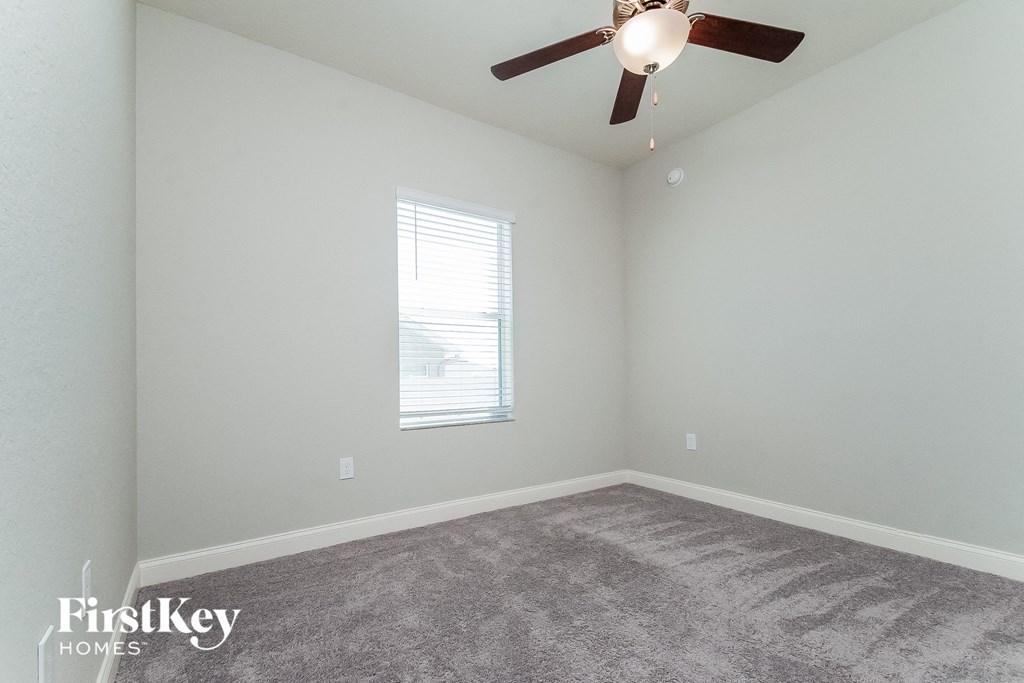 a bedroom with carpet and a ceiling fan