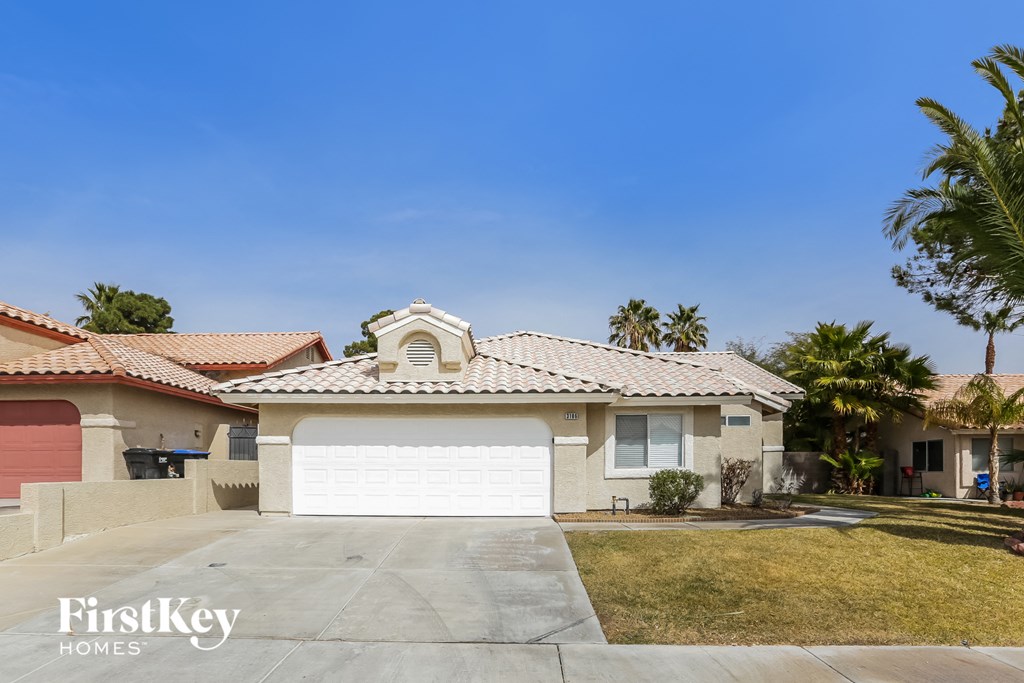 a home with a white garage door and palm trees