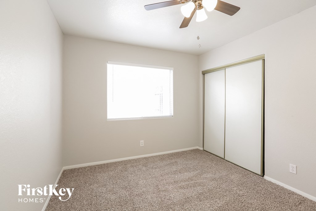 a bedroom with a ceiling fan and a closet