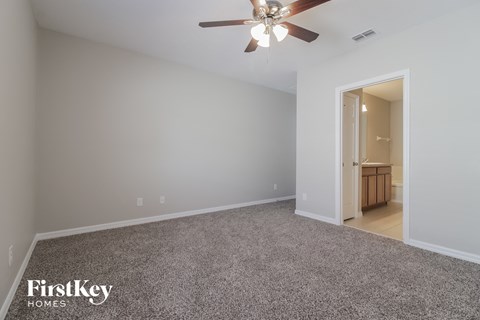 a bedroom with a carpeted floor and a ceiling fan