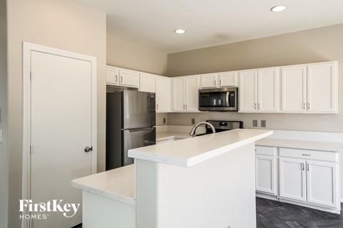 A kitchen with white cabinets and appliances.