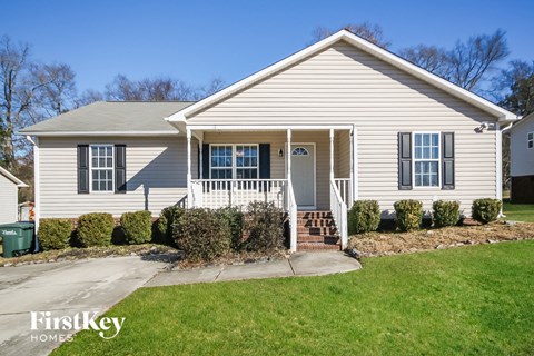 A house with a white front porch and a small front yard.