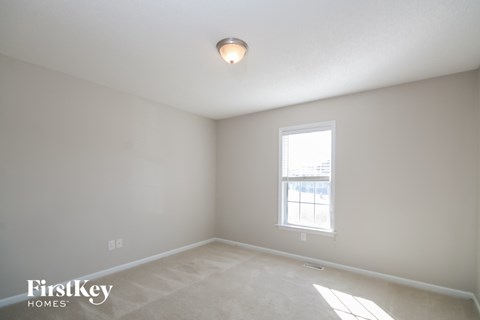A room with a window and a light on the ceiling.