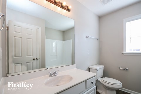 A bathroom with a white sink and toilet.