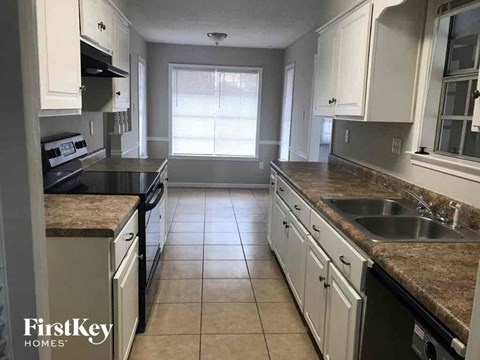 A kitchen with white cabinets and a granite countertop.