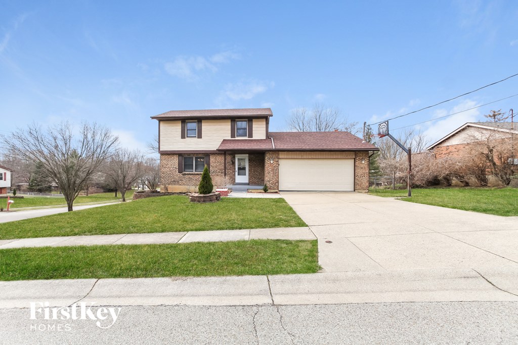 A house with a brown roof and a white garage door is for sale.