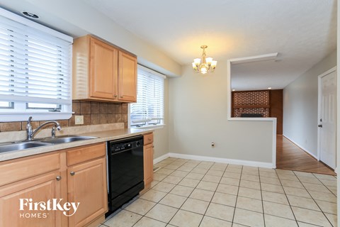 A kitchen with wooden cabinets and a tiled floor.