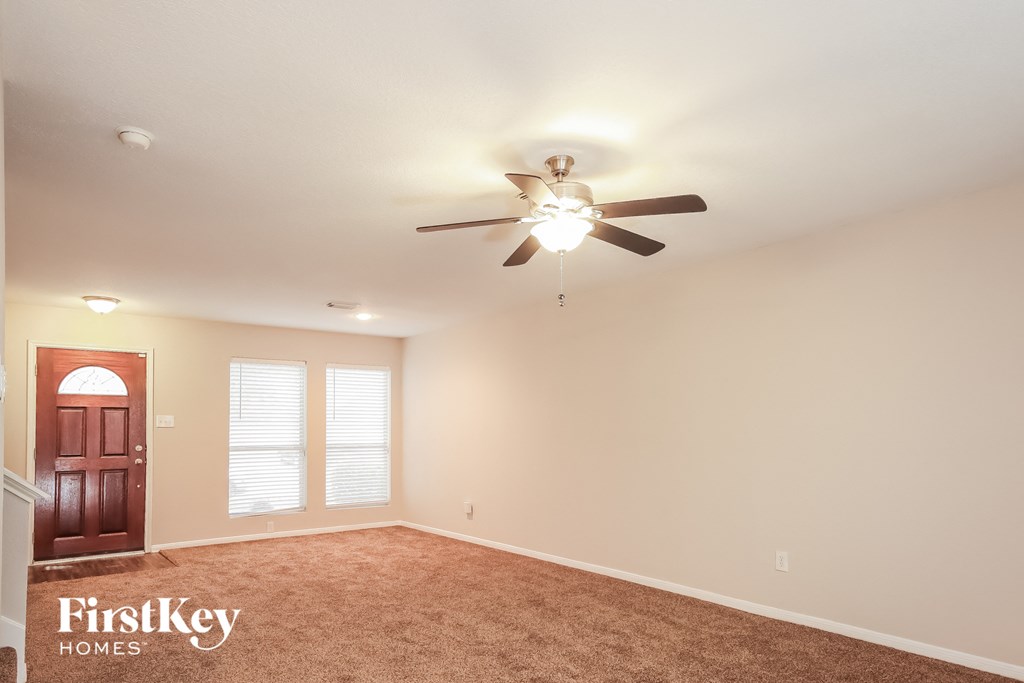 an empty room with a ceiling fan and a door