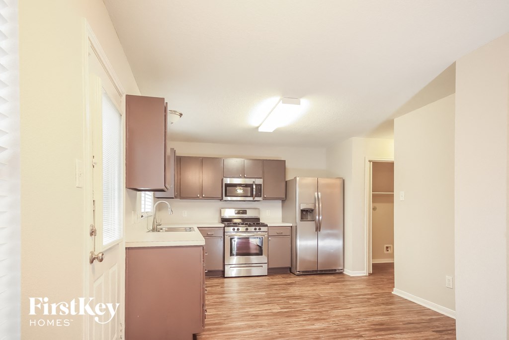a kitchen with stainless steel appliances and a wooden floor