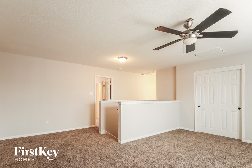 a bedroom with a ceiling fan and a door to a closet