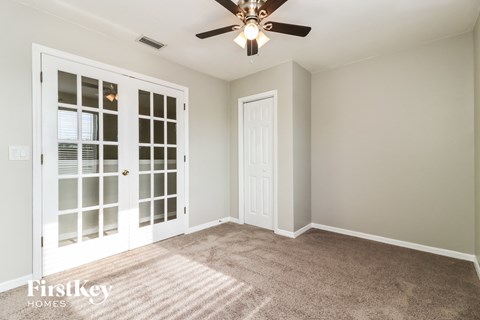 a living room with carpet and a ceiling fan