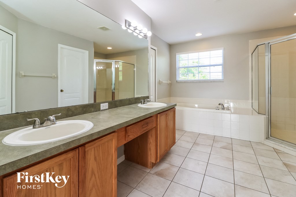 a bathroom with two sinks and a shower and a tub