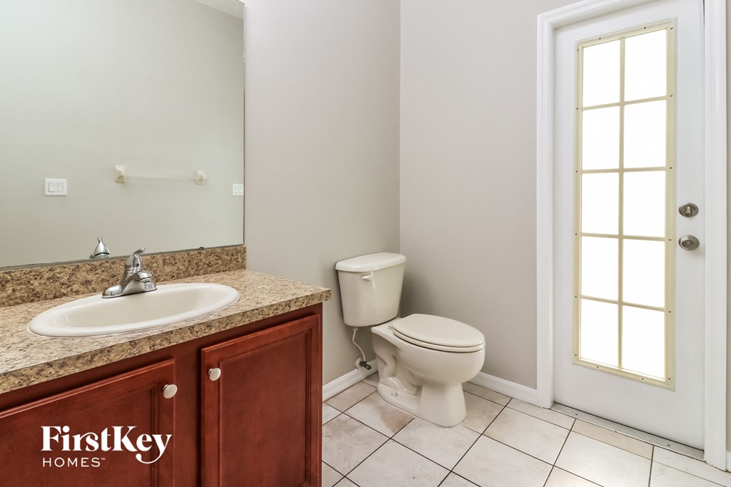 a bathroom with a toilet and a sink and a mirror