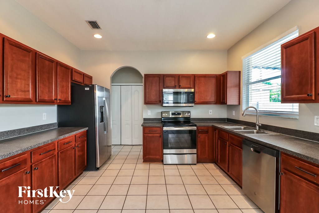 a kitchen with wooden cabinets and stainless steel appliances
