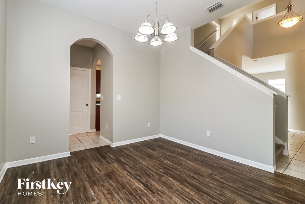an empty living room with wood flooring and a staircase