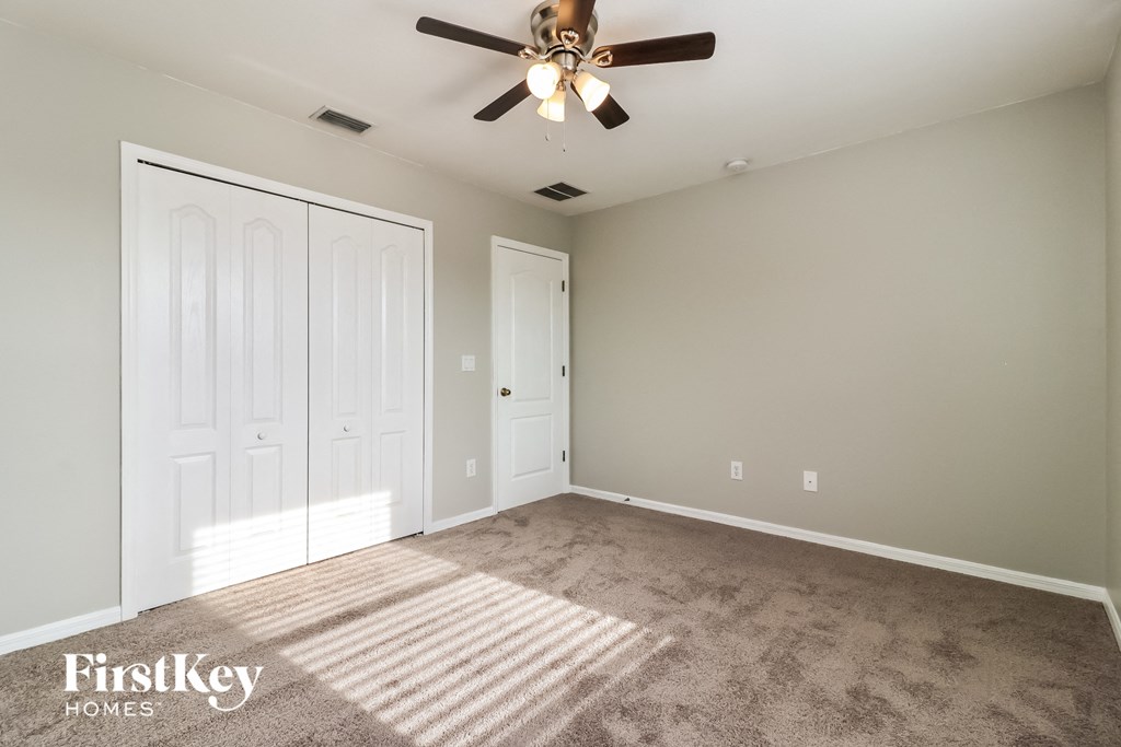 a bedroom with carpet and a ceiling fan