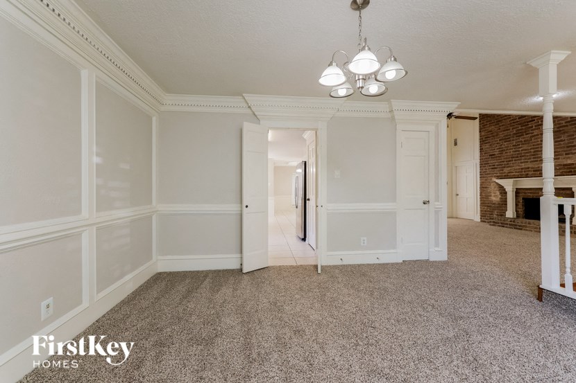 an empty living room with white walls and carpet