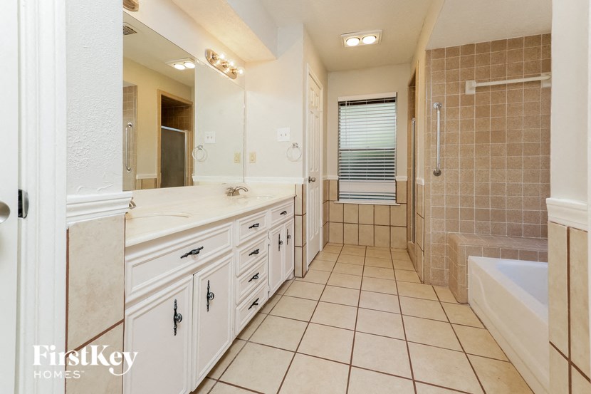 a large white bathroom with a shower and a sink
