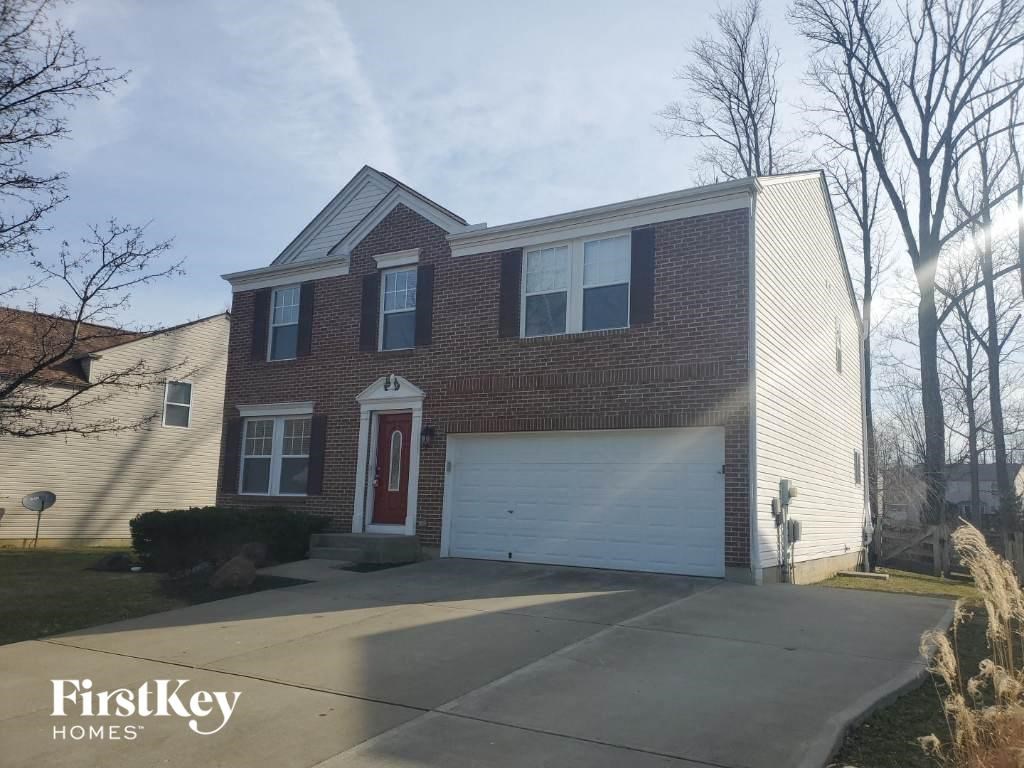 A brick house with a red door and a garage door.