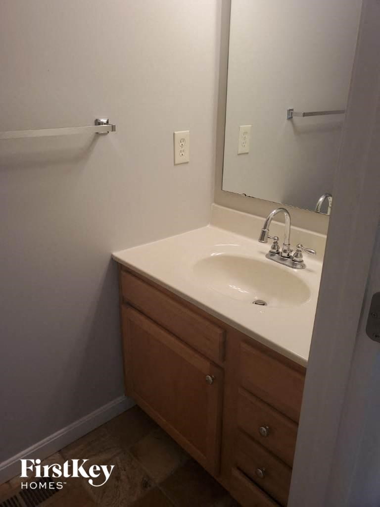 A bathroom with a sink and a mirror.