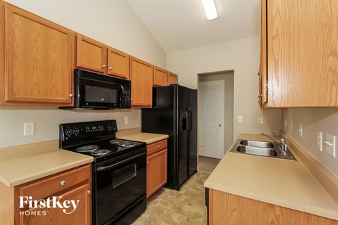 a kitchen with black appliances and wooden cabinets