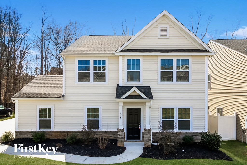 A two-story house with a white exterior and a black front door.