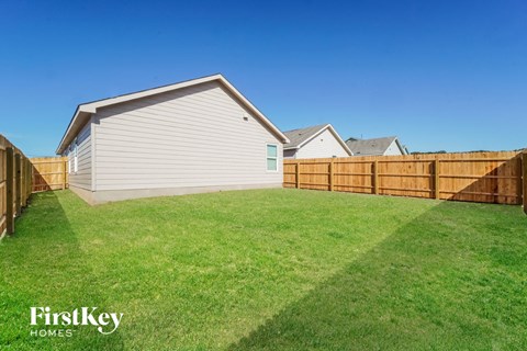 A house with a fence and a grassy yard.