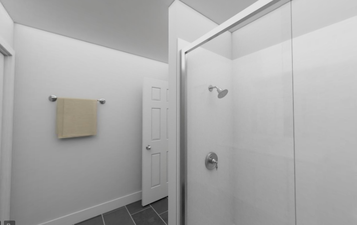 a white bathroom with a shower and a door
