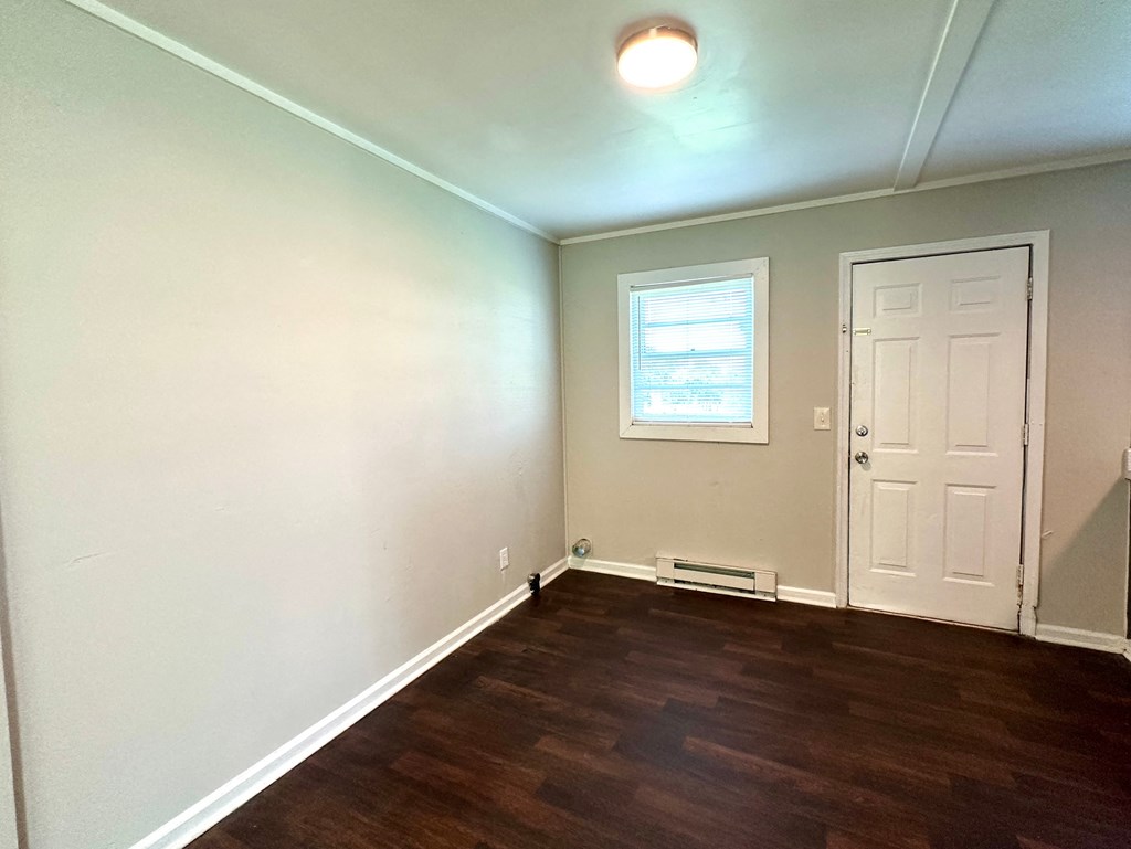 an empty room with wooden floors and a white door