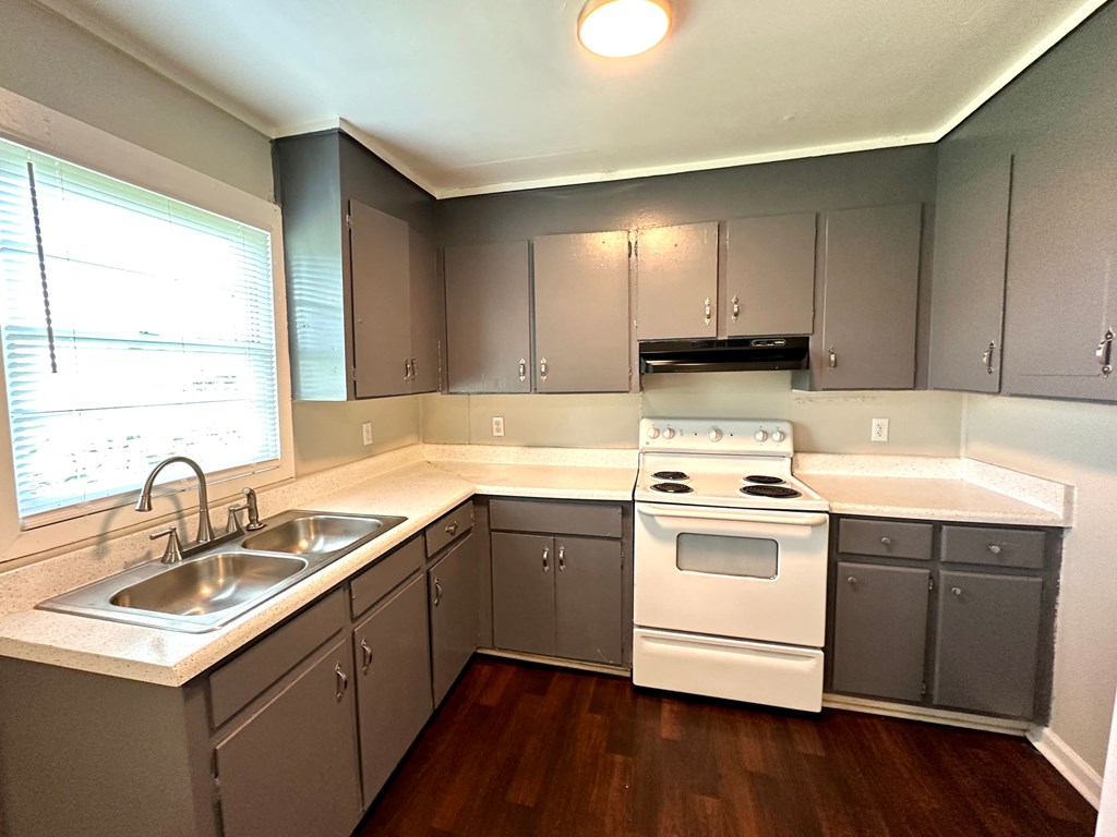 an empty kitchen with stainless steel cabinets and white appliances