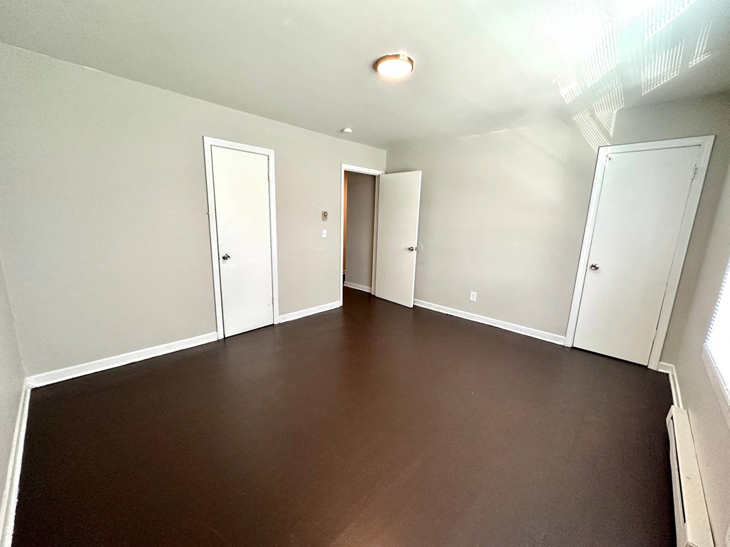 a empty living room with wood floors and white walls