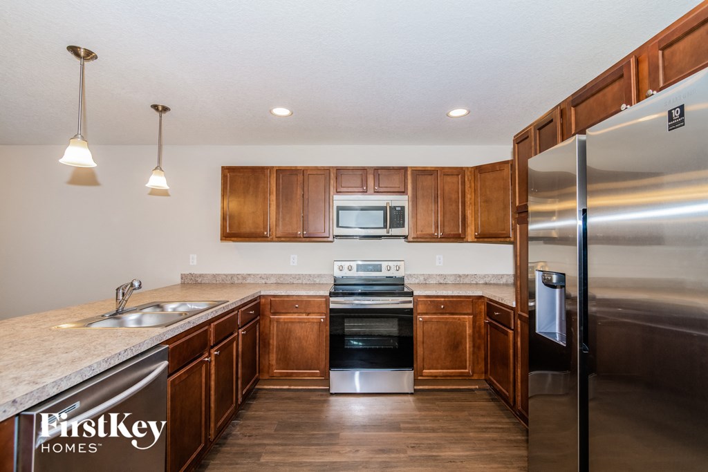 a kitchen with wooden cabinets and stainless steel appliances