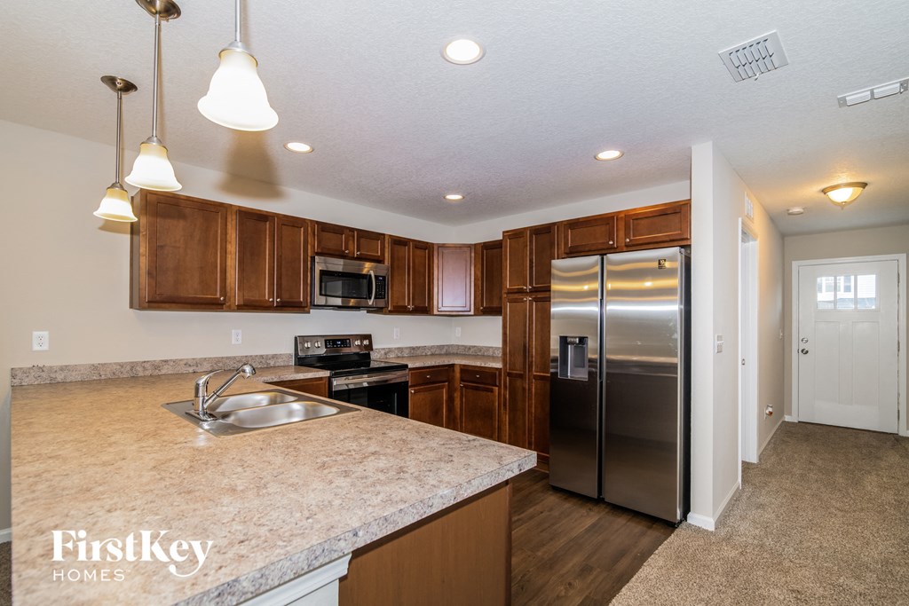 a kitchen with wooden cabinets and a stainless steel refrigerator