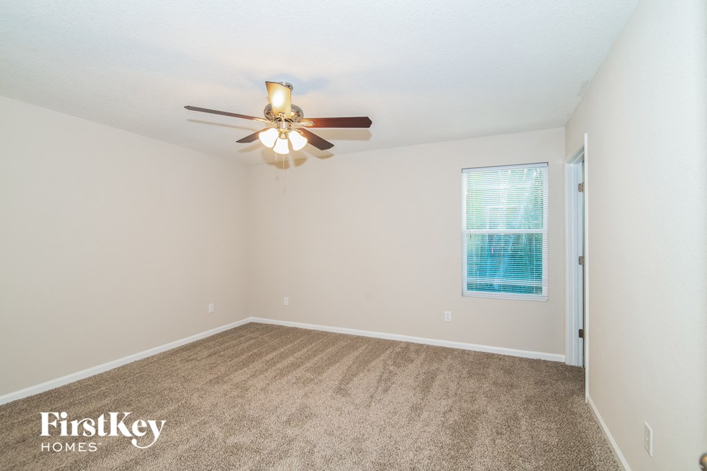 a bedroom with carpet and a ceiling fan