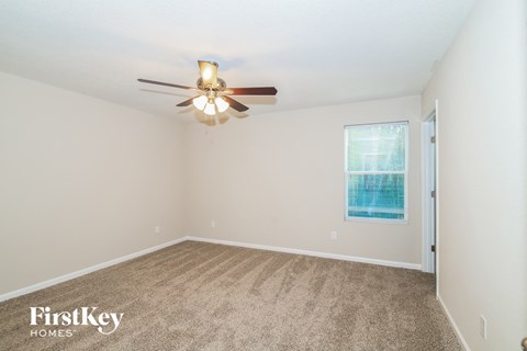 a bedroom with carpet and a ceiling fan