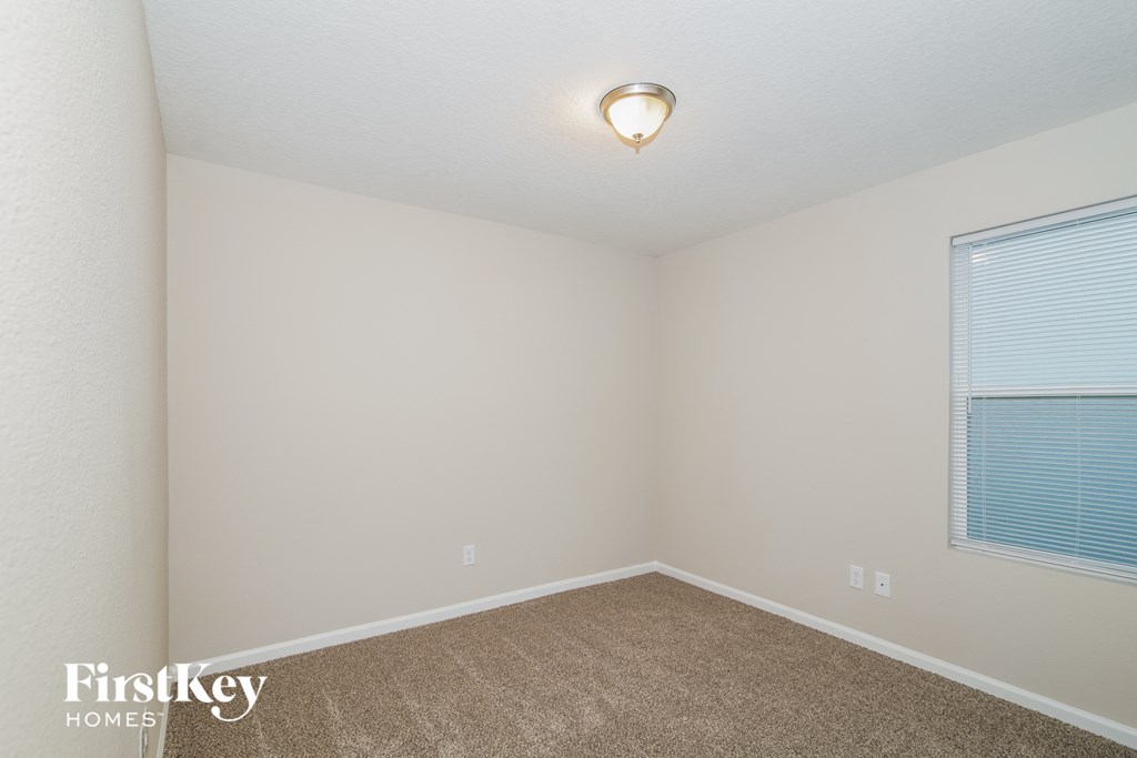 a bedroom with a carpeted floor and a large window