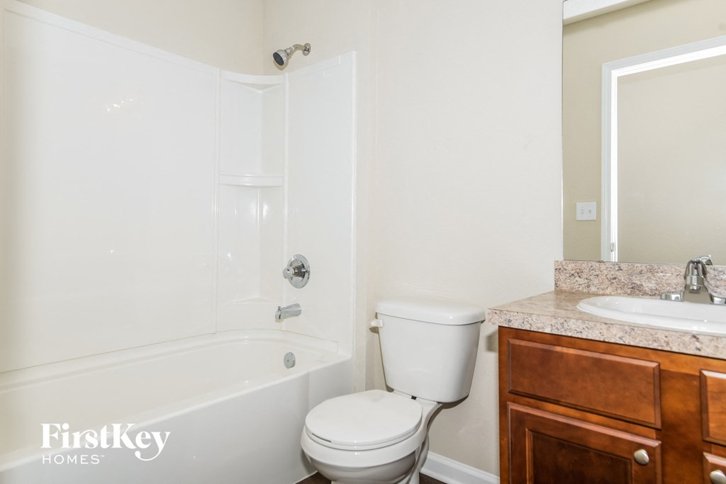 a bathroom with a toilet and a tub and a sink